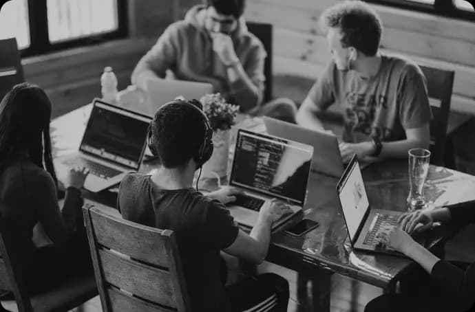 People around a table working on their computers